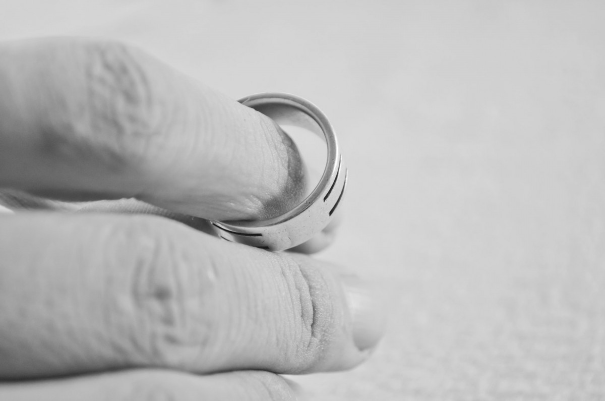 Photo of a person's hand with a wedding ring in it