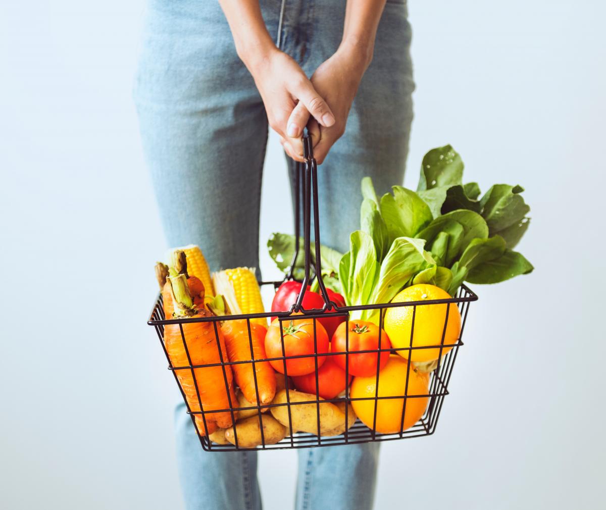 Photo of a person holding a basket full of groceries
